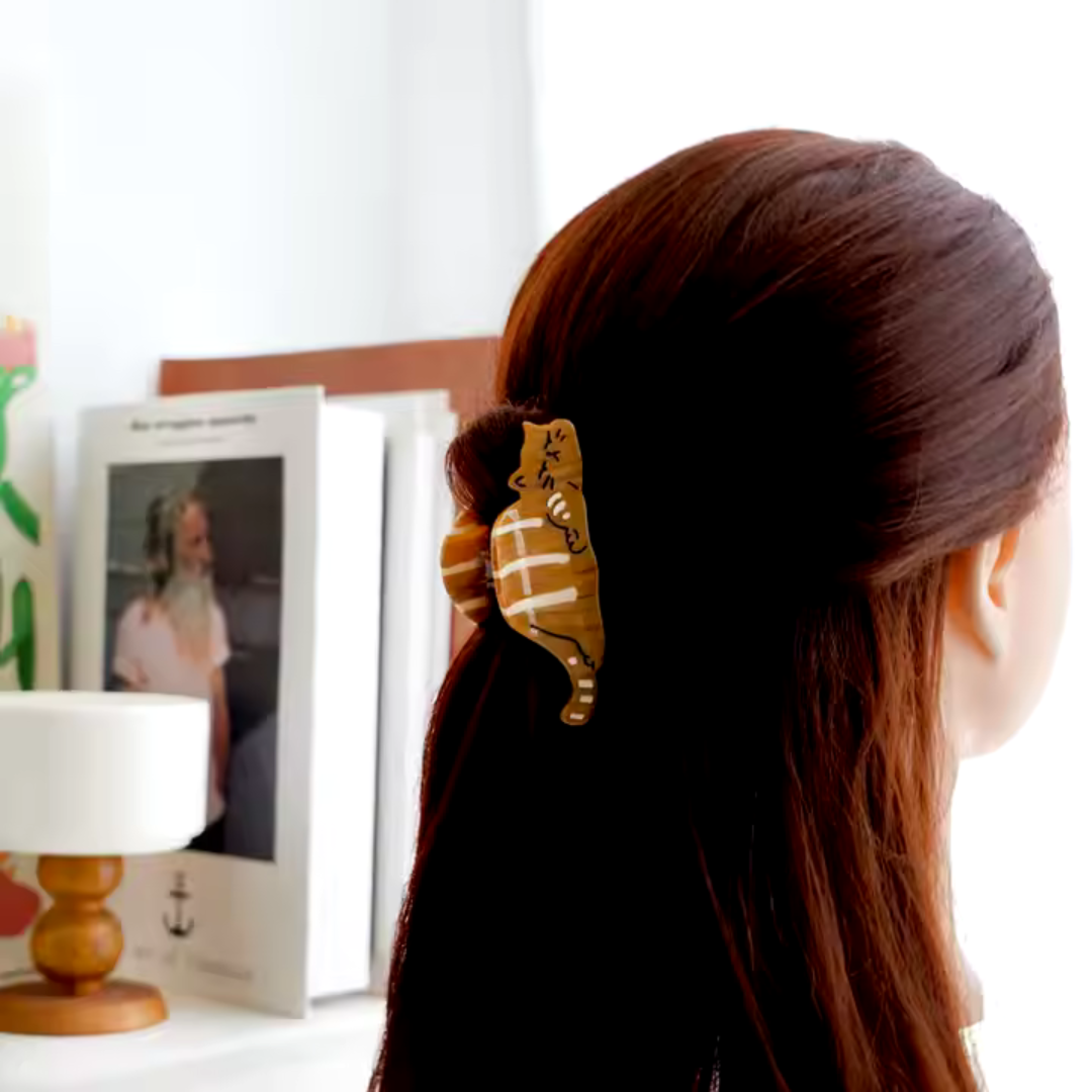 Cat Shaped Claw Style Clip is holding back the hair of a woman as she looks away. The linked collection contains all of the hair care products offered by the Good Planet Company. 