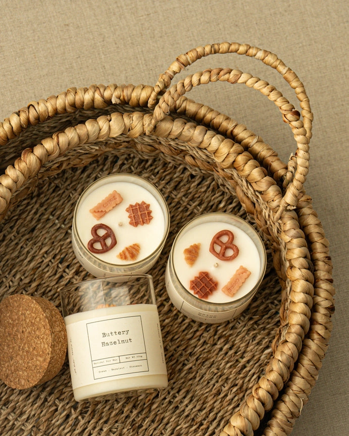 Three handmade eco-friendly candles inside of a handwoven basket. 